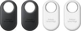 Four Galaxy SmartTags in black and white on a white background. Front view of the Samsung Galaxy SmartTag2 Bluetooth tracker, showcasing its redesigned pill-shaped white casing with a large premium metal-lined cutout loop on a clean background.